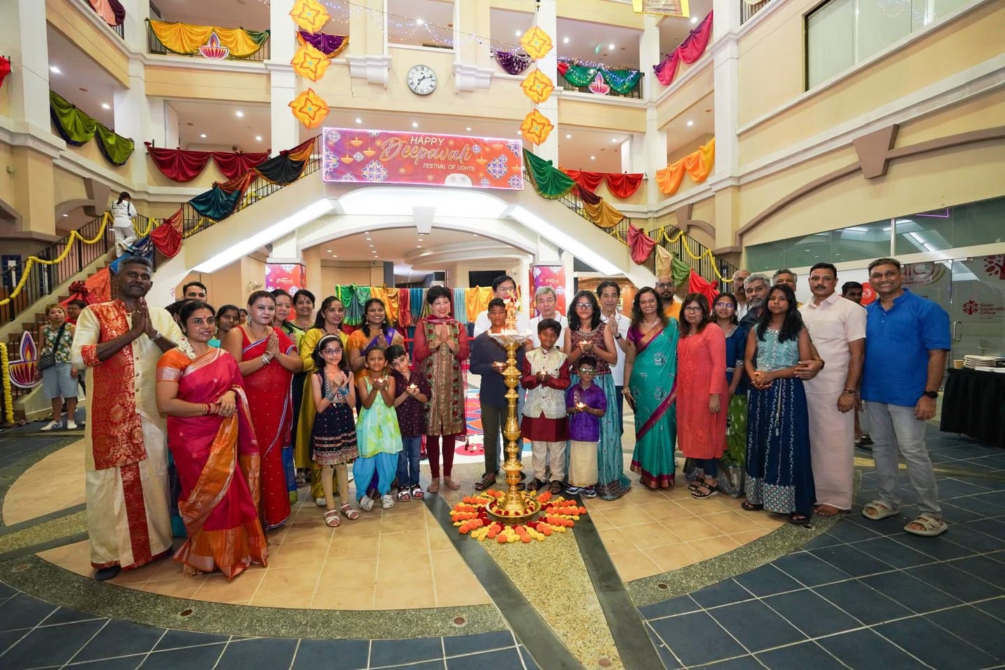 Close-up of the intricately draped sarees forming a colourful backdrop for Deepavali celebrations.
