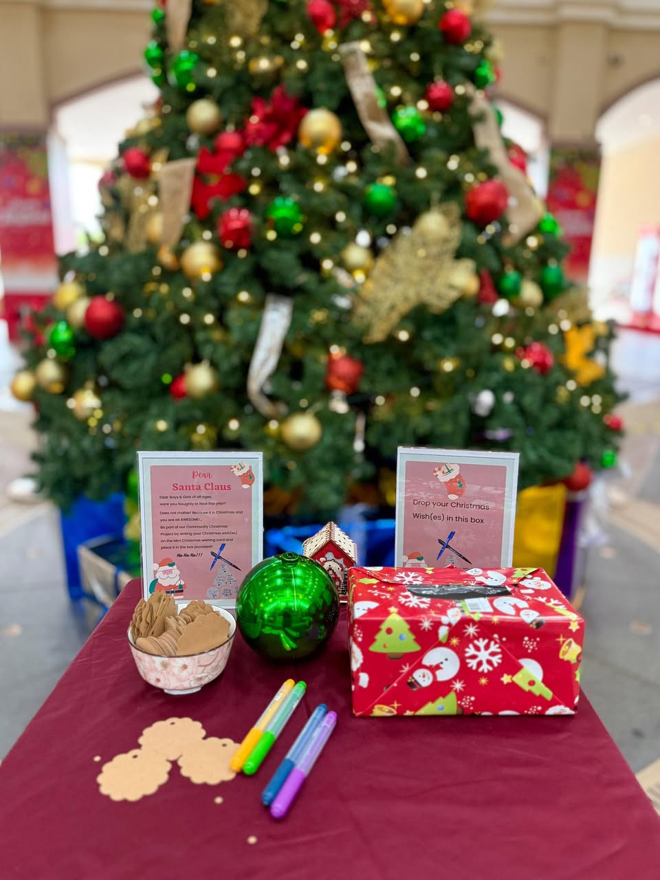 Close-up of a community Christmas tree adorned with handwritten wish cards.