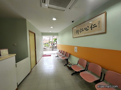 The image shows a waiting area with chairs and a framed calligraphy.